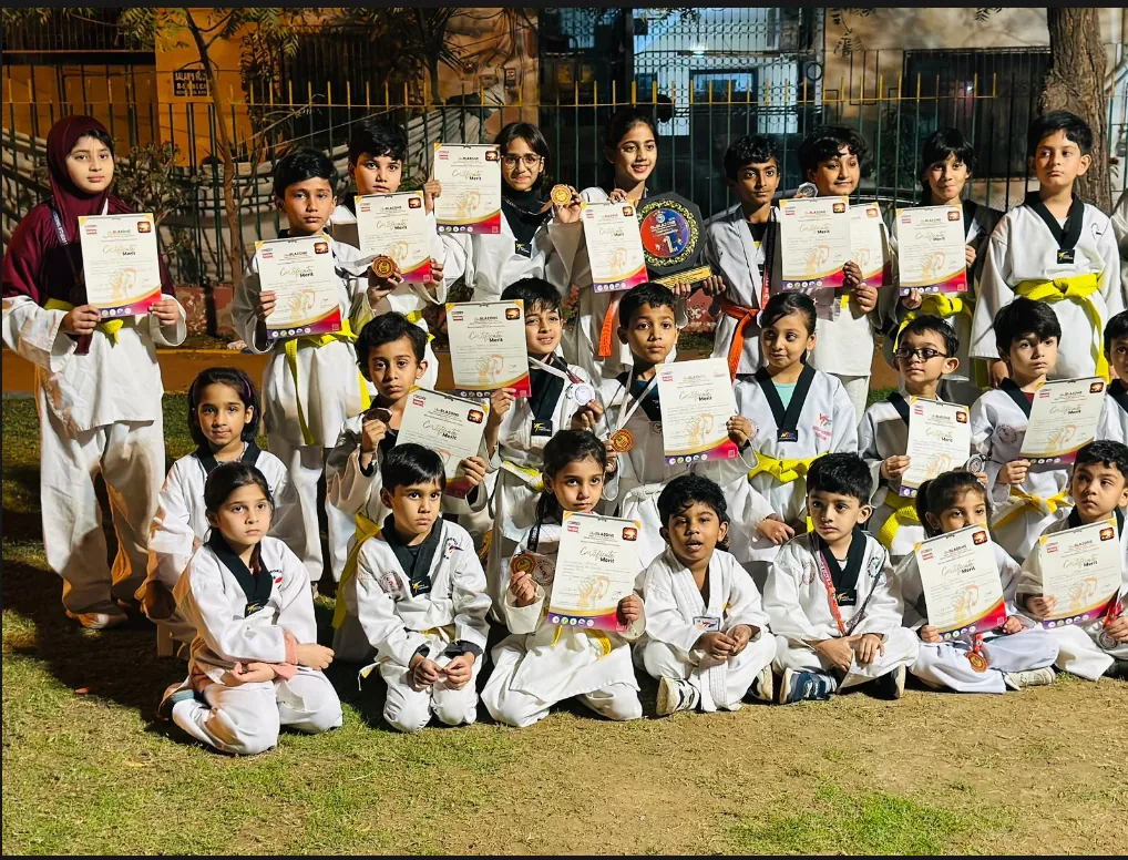 Saad bin Abi Waqas Taekwondo Club students with certificates, medals and a trophy